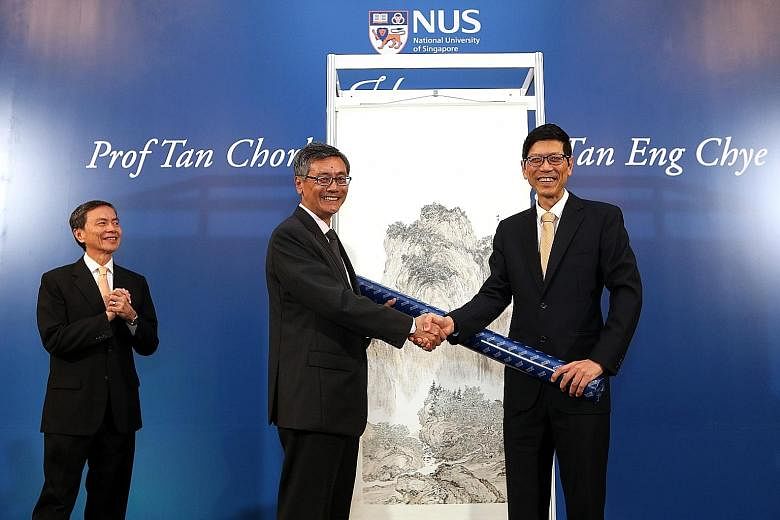 Professor Tan Chorh Chuan (right) presenting a painting he did to NUS president Tan Eng Chye, his successor. In the background is another painting by Prof Tan Chorh Chuan.