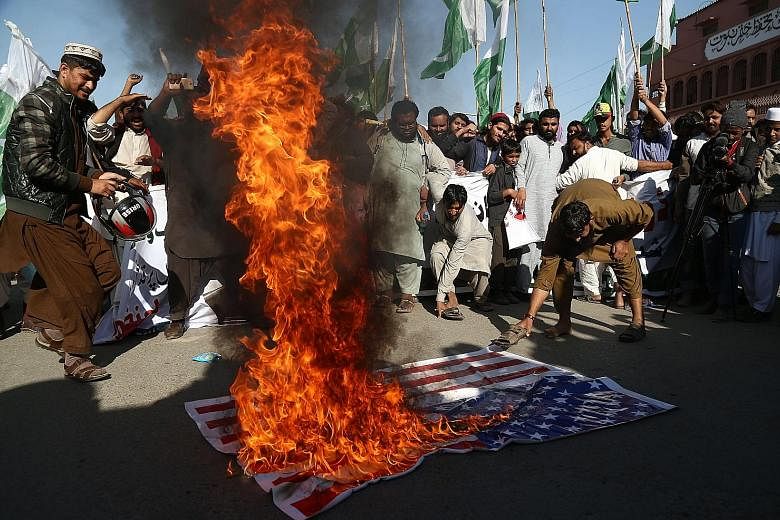 Supporters of banned Islamic charity group Jamaat-ud-Dawa burning a US flag during a protest in Karachi on Tuesday. US President Donald Trump's recent critical tweet of Pakistan will stoke support for hardline Islamist groups in the country and give 