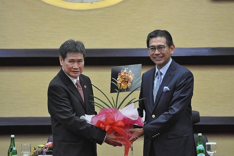 Singapore Ambassador Tan Hung Seng (right) presenting the new Secretary-General of Asean, Mr Lim Jock Hoi, with a special hybrid orchid at a ceremony in Jakarta yesterday.