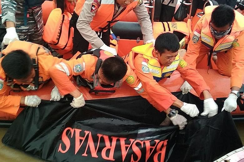Rescuers recovering a body from the Musi River in Palembang, Sumatra, after a boat carrying 55 people hit a large wave and sank amid bad weather on Wednesday.