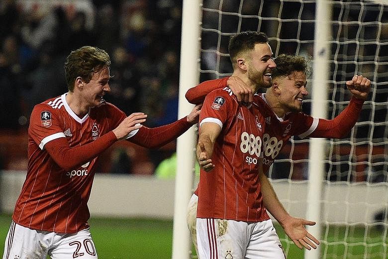 Striker Ben Brereton (far left, with Matty Cash) celebrating his 64th-minute penalty against Arsenal that made it 3-1 to hosts Nottingham Forest in the English FA Cup third round. Below: Kieran Dowell's late penalty, which he accidentally kicked twic