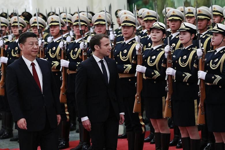 French President Emmanuel Macron and China's President Xi Jinping at a welcome ceremony with honour guards in Beijing yesterday.