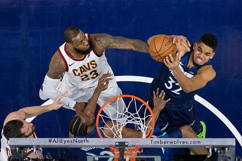 Minnesota centre Karl-Anthony Towns shooting as Cleveland forward LeBron James attempts to block him. The Cavs lost for the second time in third games on their road trip.