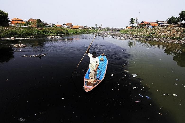 A resident collecting plastic and other recyclables on the Citarum River, located 70km east of Jakarta, whose water has partially turned black because of chemical waste and dyes discharged from factories operating along its banks. Wet markets and ani