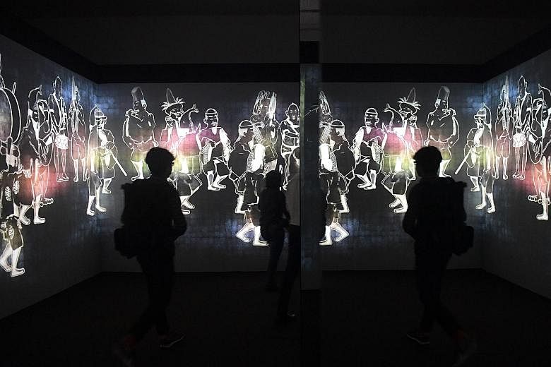 Visitors at an immersive digital installation by teamLab titled Walk, Walk, Walk: Search, Deviate, Reunite in the Ngee Ann Kongsi Concourse Gallery of the National Gallery Singapore. The second Light to Night Festival, led by the National Gallery, re