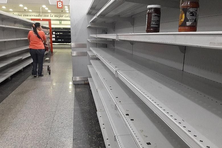 Empty shelves in a supermarket in Caracas on Thursday. Food shortages and hyperinflation have left millions of Venezuelans hungry.