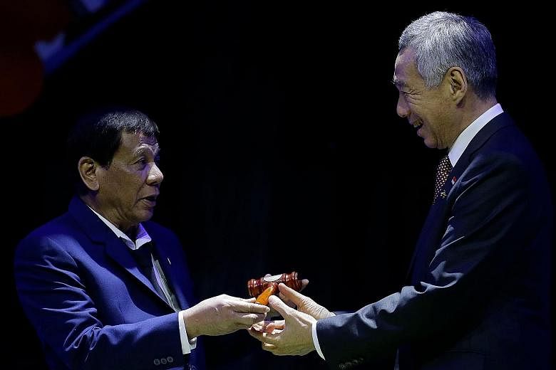 Philippine President Rodrigo Duterte handing Prime Minister Lee Hsien Loong a gavel to symbolise the handover of the Asean chairmanship to Singapore at the closing ceremony of the Asean Summit last year. Asean delegates, world leaders and officials a