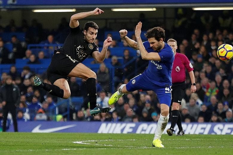 Chelsea's Cesc Fabregas attempting to block a shot from Leicester's Matty James during their 0-0 English Premier League draw at Stamford Bridge yesterday. The Foxes ended with 10 men after Ben Chilwell's second yellow card. The draw was the Blues' fo