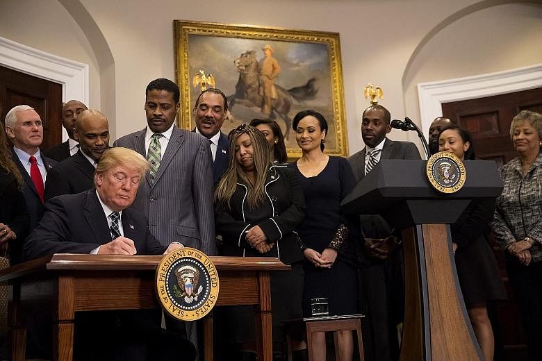 President Donald Trump signing a proclamation for Martin Luther King Jr Day in the White House on Friday. The event marking the King holiday was planned long before the uproar over Mr Trump's latest comments, but it put the stigma that his words have