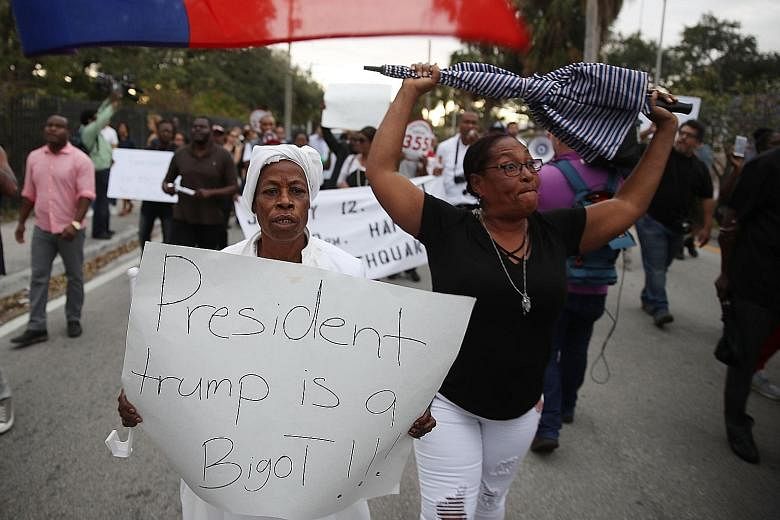 A demonstrator in Miami adds her view to the chorus of condemnation of President Donald Trump's reported statement about immigrants from Haiti, Africa and El Salvador.