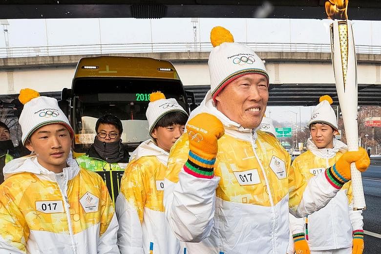 South Korean football legend Cha Bum Kun with the Olympic flame during the Pyeongchang 2018 Torch Relay near the World Cup Stadium in Seoul yesterday. The torch will be paraded for four days before making its way to Pyeongchang for the start of the W
