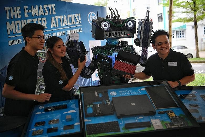 (From left) HP Singapore intern Darren Chia, marketing manager Sheryl Chan and managing director Lionel Chng with the E-waste Monster at the HP Make IT Green Campaign, held in conjunction with South West Community Development Council's annual trash-f