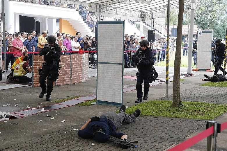 Police officers responding to a simulated attack by "gunmen" near Taman Jurong Community Club yesterday. The live exercise was part of the Taman Jurong Emergency Preparedness Day - an event held in constituencies islandwide under the SGSecure program