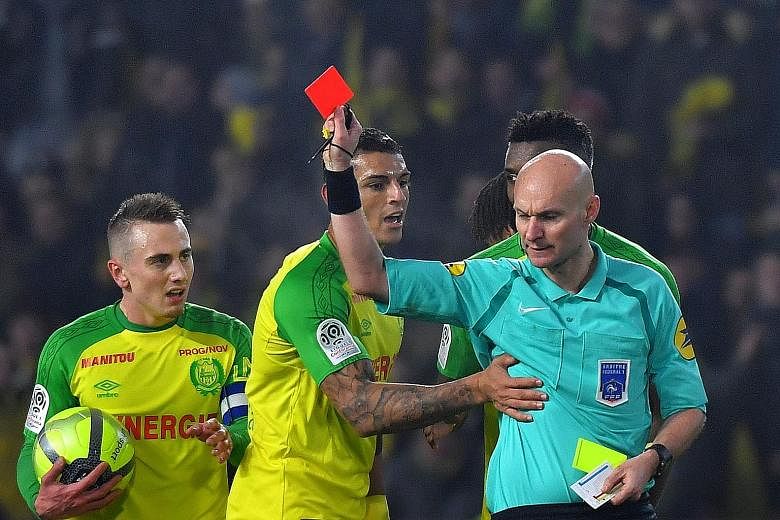 French referee Tony Chapron showing Nantes defender Diego Carlos (second from left) a red card on Sunday. Chapron, who kicked the Brazilian after an accidental collision during the game against Paris Saint-Germain, has been suspended by the French Fo