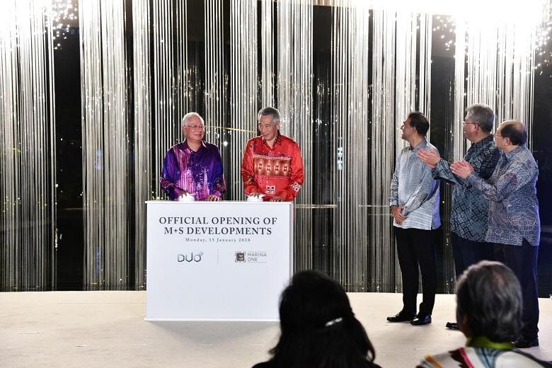 Prime Minister Lee Hsien Loong and his counterpart Datuk Seri Najib pressing the launch mechanisms to officially open Marina One and Duo at the ceremony last night. With them were (from right) Temasek International chief executive Lee Theng Kiat, Kha