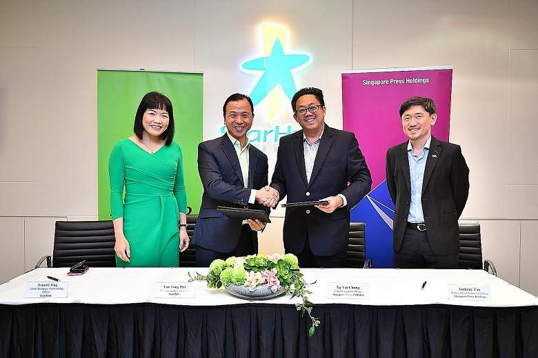 StarHub chief executive Tan Tong Hai (second from left) and SPH CEO Ng Yat Chung shaking on the agreement at the MOU signing yesterday, witnessed by StarHub chief strategic partnership officer Jeannie Ong and SPH deputy CEO Anthony Tan. The tie-up wi