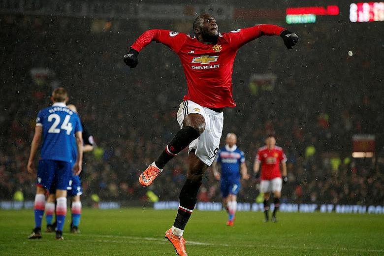 Manchester United striker Romelu Lukaku jumps for joy after scoring their final goal in Monday's 3-0 win against Stoke City that cut leaders Manchester City's lead to 12 points.