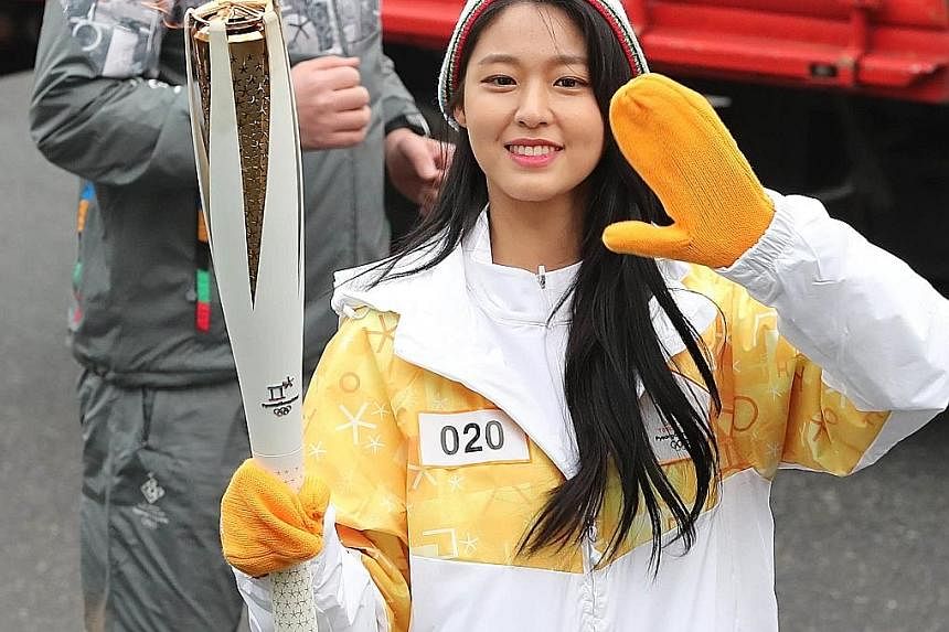 South Korean girl group AOA's Seol Hyun carrying the Winter Olympics torch in Seoul on Tuesday, as part of a nationwide relay tour.
