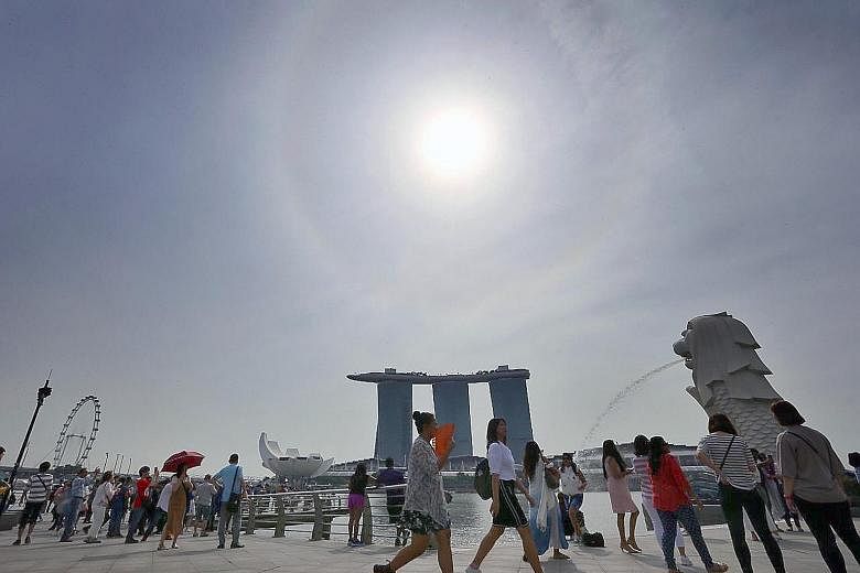 At Merlion Park on Tuesday. Fewer rainy days are expected in the second-half of the month, but rainfall for the month is expected to be well above normal, and daily temperatures will range between 24 deg C and 32 deg C.