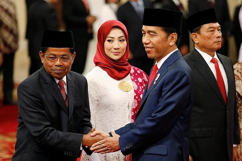 President Joko Widodo greeting the new Social Affairs Minister Idrus Marham (far left) at the swearing-in ceremony at the presidential palace in Jakarta yesterday. With them are Mr Idrus' wife Ridho Ekasari and Presidential Chief of Staff Moeldoko.