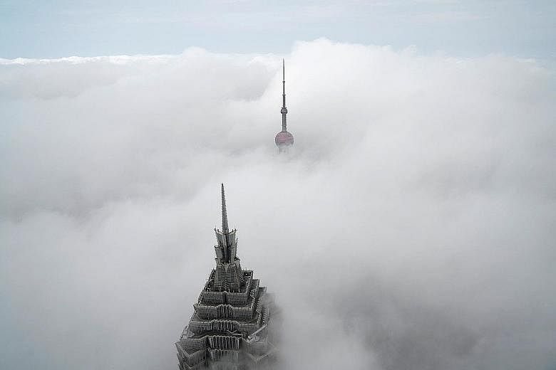 Shanghai's Oriental Pearl Tower is barely visible in the distance while only the top of the 88-storey Jinmao Tower is seen peeking out of the thick blanket of fog in this photo taken from the Shanghai World Financial Centre on Tuesday morning. The Ch