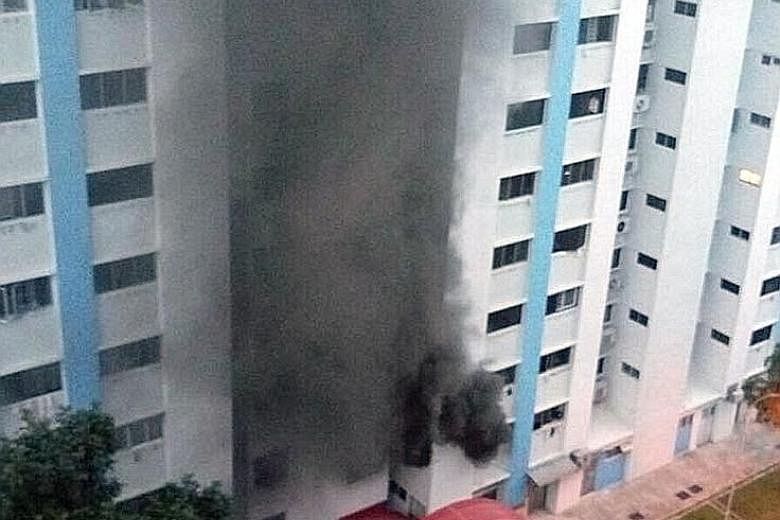 A woman in her 80s and another in her 30s were taken by ambulance to Tan Tock Seng Hospital after suffering from breathlessness. The cause of the fire in the second-floor unit (below) is being investigated. Left: The fire - seen from the front of Blo