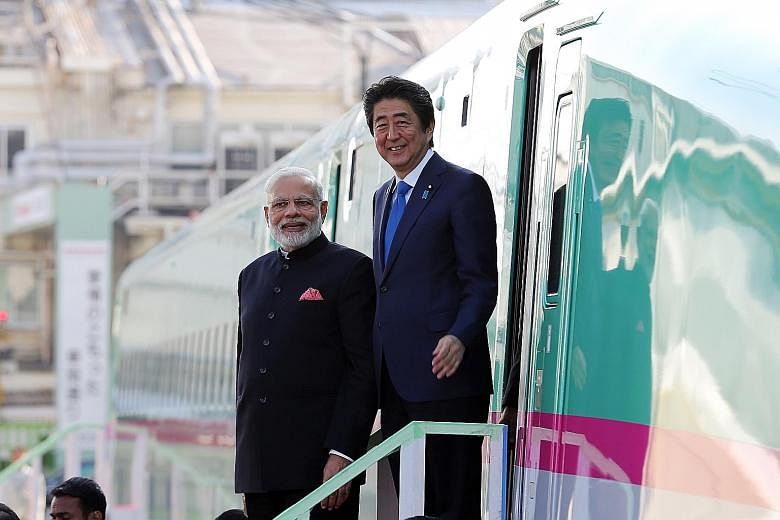 Indian Prime Minister Narendra Modi and his Japanese counterpart Shinzo Abe standing beside a Shinkansen bullet train during a 2016 visit to a Kawasaki Heavy Industries plant in Kobe, Japan.