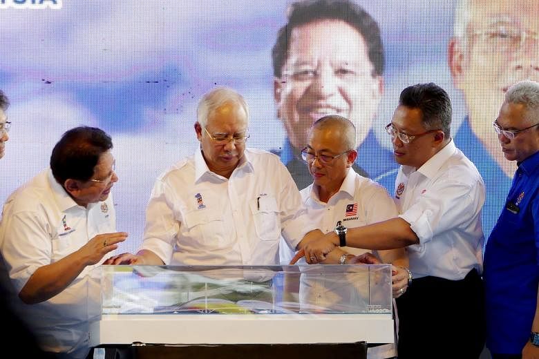 Malaysian Prime Minister Najib Razak (second from left) looking at a model of the Labuan-Sabah bridge yesterday. With him are Federal Territories Minister Tengku Adnan Tengku Mansor (far left), MP for Labuan and chairman of Labuan Corporation Rozman 