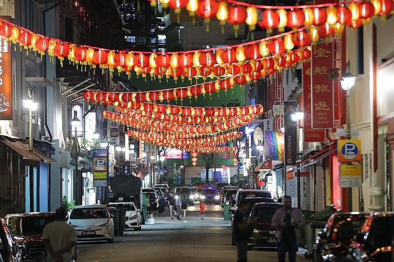 Spring is in the air in tropical Singapore, as workers put up Chinese New Year decorations along South Bridge Road and Temple Street on Tuesday night to welcome the Year of the Dog. 	To ring in the Chinese New Year, the area around Eu Tong Sen Street