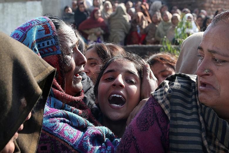 Relatives mourning near the body of Sahil Kumar, who was killed by mortar shells allegedly fired from the Pakistani side of the disputed Kashmir border in the village of Ranbir Singh Pura, about 25km from Jammu, the winter capital of Kashmir, India, 