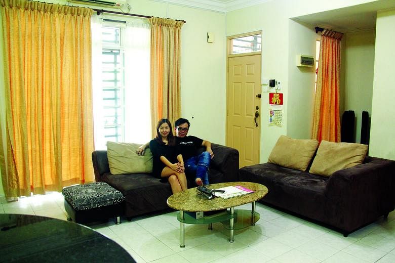 Ms Tan and Mr Ling in the living room of their 2,540 sq ft double-storey terraced house in Johor Baru's Tebrau area. She says it is "easy for my hubby and I to commute to Singapore for work" from their home.