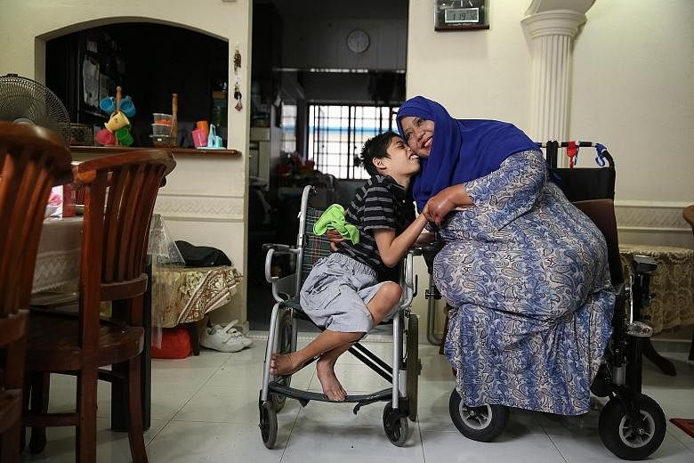 Madam Zainon Arshad with her son Huzairul Izwan. Madam Zainon lost both her legs because of diabetes. Rather than rely on her husband's income, she took up courses to learn how to make baked goods and now sells them from home, and sometimes at bazaar