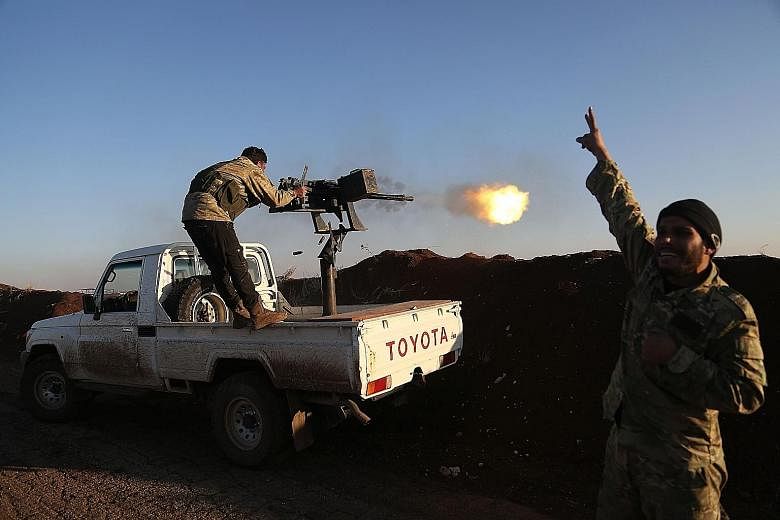 A fighter from the pro-Ankara Free Syrian Army in Tal Malid, north of Aleppo, firing towards positions where the Kurdish People's Protection Units are hiding out in the village of Um al-Hosh in Afrin province.
