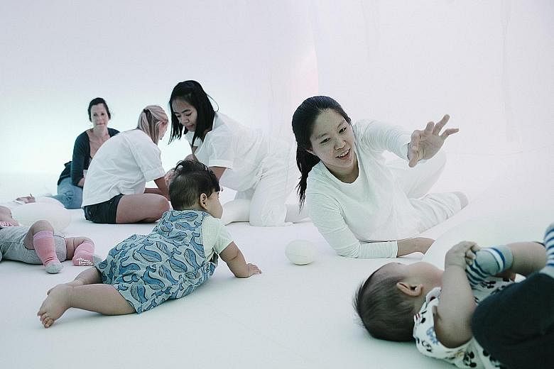 Independent dance artist Bernice Lee (left), 30, interacting with seven-month-old Ashley (foreground) as six-month-old Elyas watches on.