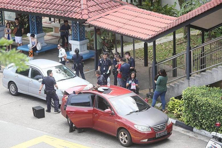Above: Police at the scene in Bishan with the two cars on Monday morning. Left: The 24-year-old woman under arrest for drug-related offences.