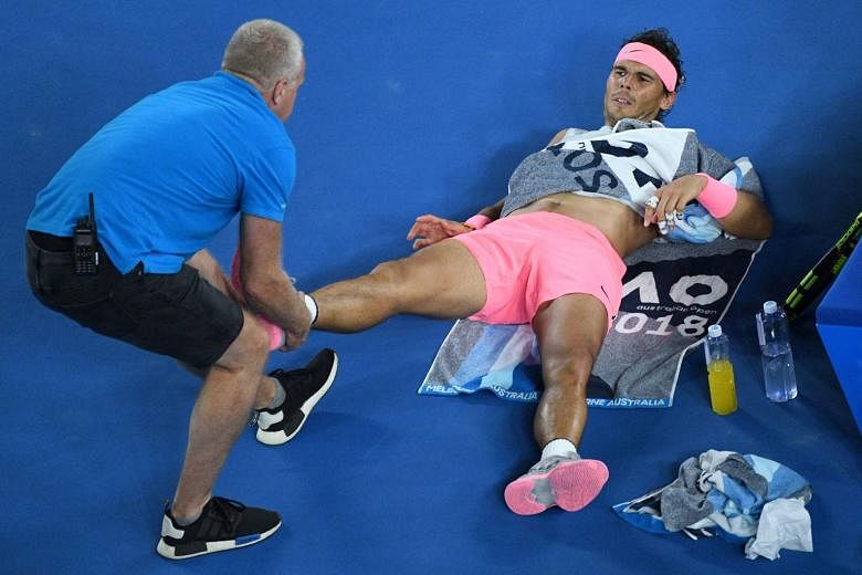 World No. 1 Rafael Nadal receiving medical attention during his quarter-final match against Croatia's Marin Cilic in Melbourne yesterday before the Spaniard retired after trailing 0-2 in the fifth set.