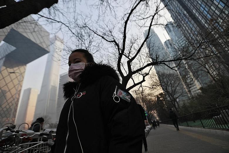 A woman wearing a mask as protection against the smog in Beijing earlier this month. Though China's capital has made progress in cutting breathable particulate matter, the level has yet to reach the official standard.