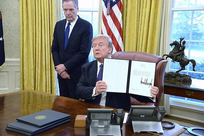 US President Donald Trump displaying the executive order after signing it at the White House on Tuesday. China's reaction has been cautious, with the Commerce Ministry suggesting that Beijing would take the case to the WTO.