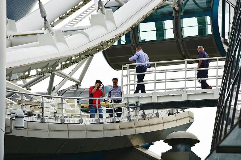 Staff at the Singapore Flyer yesterday after a technical issue at about 9am forced rides to be suspended at the tourist attraction. A notice (above, left) was put up informing people of the temporary closure. In a Facebook post, the Flyer said it wou