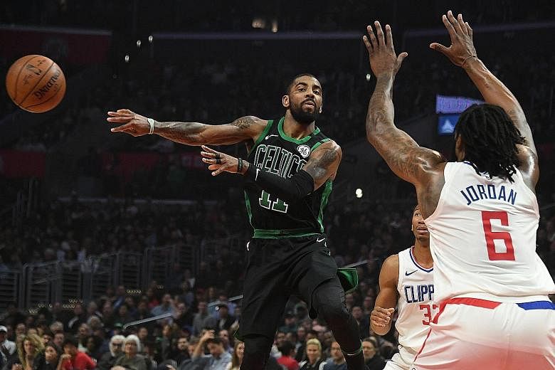 Boston Celtics point guard Kyrie Irving making a no-look pass to evade the defence of Los Angeles Clippers centre DeAndre Jordan during the first half of their National Basketball Association game at the Staples Centre. Irving scored 20 points as fiv