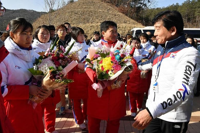 The North Korean women's ice hockey team (in white and red) arriving in South Korea's Jincheon yesterday. Athletes from both sides will march under one flag at the opening ceremony of the Pyeongchang Olympics.