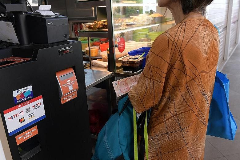 The payment kiosk at the Jurong West Street 61 hawker centre accepts both cash and cashless payments. Some hawkers say few customers opt for cashless payments.