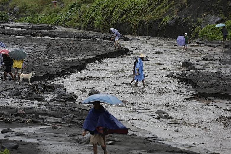 Villagers on the slopes of Mayon volcano in Albay province, following a flash flood yesterday. Mayon, the most active of the Philippines' 22 volcanoes, has been generating clouds of superheated ash and bursts of lava for nearly two weeks. Experts hav