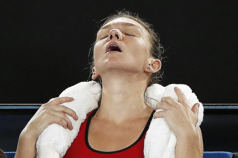 Caroline Wozniacki (top) kissing the trophy after beating Simona Halep 7-6, (7-2), 3-6, 6-4 yesterday to win her first Major at her 43rd attempt - becoming the first Dane to win a Grand Slam singles title; the Romanian Halep (above) receiving medical