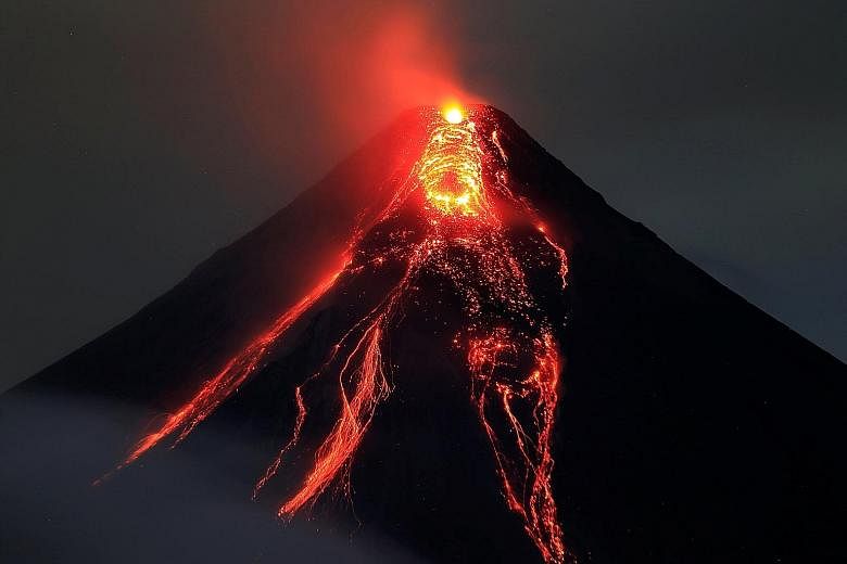 Mount Sinabung spewing thick smoke in Karo, in Indonesia's North Sumatra, on Jan 6 as a farmer harvests his vegetables. Lava flowing from the crater of Mount Mayon volcano during a new eruption in Albay province, Philippines, last Thursday. The volca