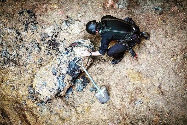 A bomb disposal officer examining an unexploded 450kg wartime bomb found at a Wan Chai building site on Saturday. Officers said it was dropped from the air by American bombers some time between 1941 and 1945.