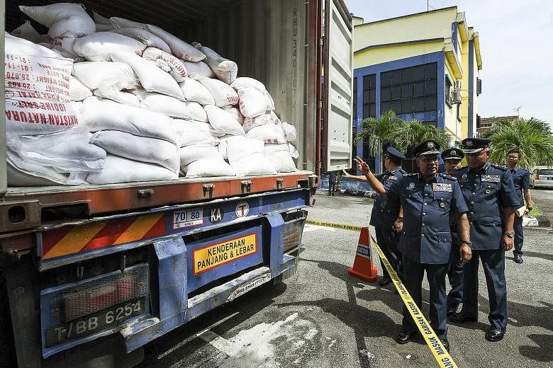 Malaysia's director-general of Customs Subromaniam Tholasy (front) said the sacks of drugs came from Karachi, Pakistan. The 37 sacks were among 1,885 sacks of salt that 18 foreigners were found unloading when the makeshift store in Selangor was raide