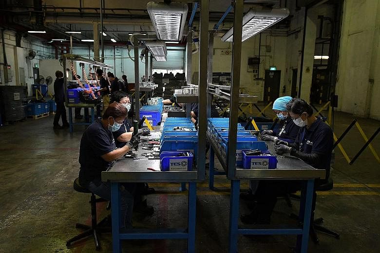 Workers disassembling electronic devices at TES-AMM, one of six main e-waste recycling companies in Singapore. The recycler said that only about 5 per cent of the 60,000 tonnes of e-waste generated here goes through it.