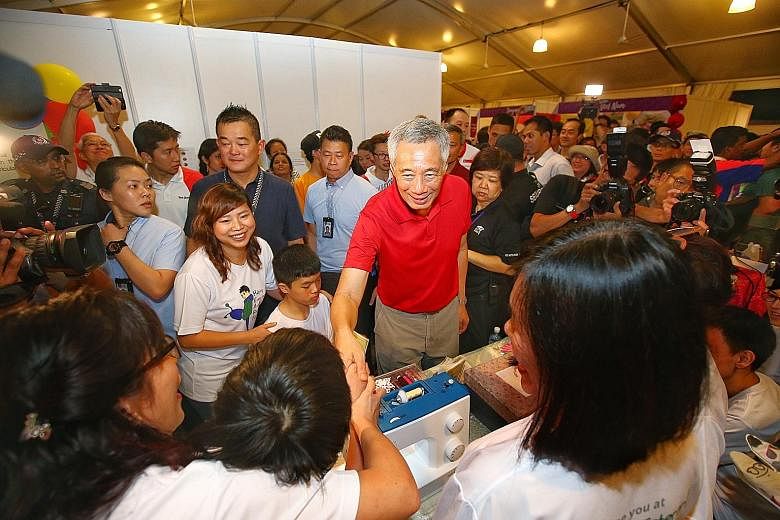 Prime Minister Lee Hsien Loong visiting a booth at the Experience Asean festival at Bishan-Ang Mo Kio Park last month. PM Lee, who has said he hopes not to stay on as PM beyond age 70, has about four years to hand over the post. But having him stay o