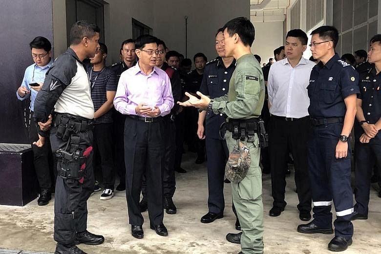 Finance Minister Heng Swee Keat being briefed by officers from the Singapore Police Force and Singapore Civil Defence Force during a visit to the Home Team Tactical Centre yesterday.